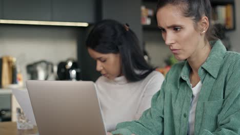 Two-very-focused-women-working-on-computer-at-home