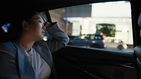 Business-Chinese-woman-driving-in-a-taxi-at-night