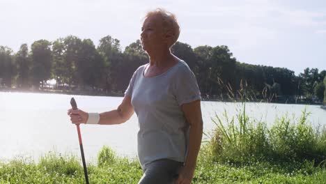 Senior-woman-practicing-nordic-walking--in-the-park