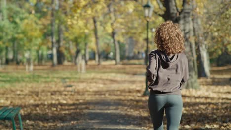 Rear-view-of-ginger-woman-running-at-the-park-in-autumn