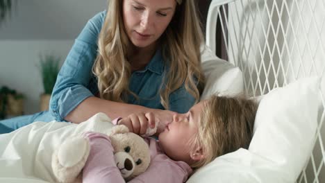 Mother-taking-care-of-her-ill-daughter-at-home
