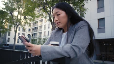 Mujer-China-De-Negocios-Navegando-Por-Teléfono-Móvil