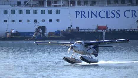 Close-Up-Front-View-of-a-Seaplane-Taking-Off-Next-a-Cruise-Ship-TRACK