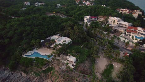 Aerial-views-of-the-exterior-of-a-luxury-hotel-resort-nestled-amidst-lush-trees-in-Huatulco