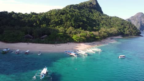 Playa-De-La-Isla-Helicóptero-En-El-Nido-Con-Barcos-Turísticos-Que-Van-De-Isla-En-Isla