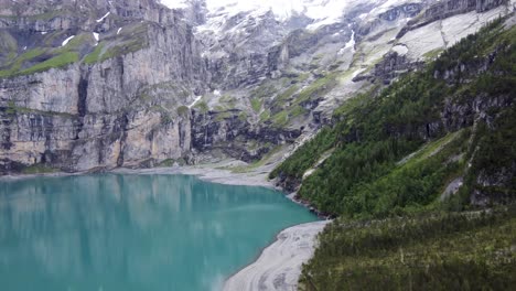 Swiss-alpine-Oeschinen-Lake-with-its-turquoise-blue-water-amid-Bluemlisalp-alps-mountains-in-kandersteg,-Switzerland