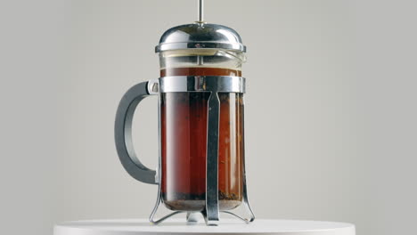 Modern-coffee-french-press,-spinning-against-grey-background