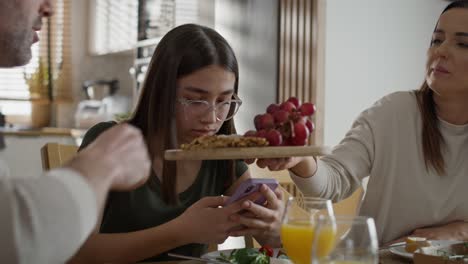 Süchtiges-Teenager-Mädchen-Benutzt-Mobiltelefon-Während-Des-Frühstücks-Am-Tisch
