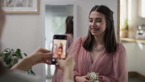 Mother-taking-and-checking-picture-of-her-daughter-in-dress-before-prom-party