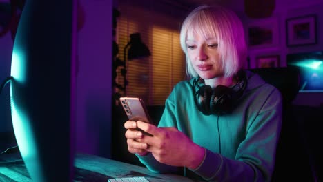 Young-caucasian-woman-browsing-mobile-phone-while-a-break-during-playing-game-at-night-on-Desktop-P