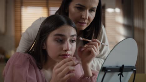 Caucasian-woman-teaching-daughter-how-to-do-make-up-for-a-prom