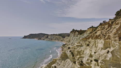 Scala-dei-Turchi-Italy-Aerial-v4-cinematic-tracking-reveal-shot-capturing-azure-coastal-landscape-of-white-marl-cliffs,-unique-rock-formations-in-Mediterranean-sea---Shot-with-Mavic-3-Cine---June-2023