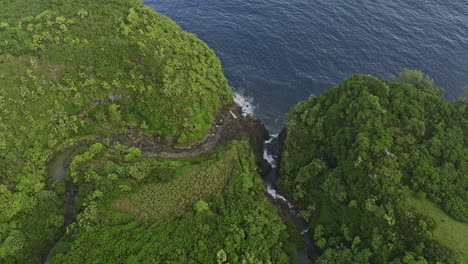 Maui-Hawaii-Aerial-v35-birds-eye-view-flyover-Nailiilihaele-and-Kailua-streams,-water-flow-and-cascade-from-rocky-cliffs-into-the-ocean,-amidst-lush-vegetation---Shot-with-Mavic-3-Cine---December-2022