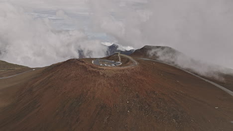 Maui-Hawaii-Luftaufnahme-V28-Überflug-über-Den-Roten-Hügel-In-Haleakala,-Aufnahme-Der-Charakteristischen-Rötlichen-Vulkanschlacke-Und-Erde-Auf-Dem-Berggipfel-Und-Der-Hochgelegenen-Wolkenlandschaft-–-Aufgenommen-Mit-Mavic-3-Cine-–-Dezember-2022