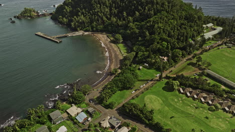 Hana-Maui-Hawaii-Aerial-v8-cinematic-birds-eye-view-drone-flyover-the-bay-capturing-beach-park,-coastal-town-center,-waterfront-residential-neighborhood---Shot-with-Mavic-3-Cine---December-2022