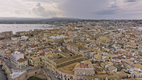 Syracuse-Italy-Aerial-v1-cinematic-flyover-and-around-Ortigia-Island-capturing-charming-Mediterranean-coastal-town-with-historical-stone-architectural-buildings---Shot-with-Mavic-3-Cine---June-2023
