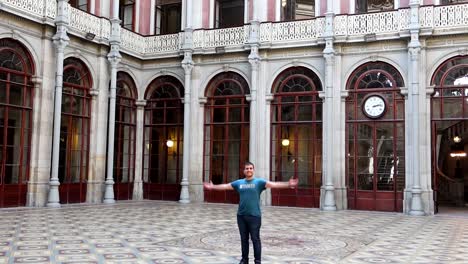 Happy-caucasian-man-spin-in-Courtyard-of-Nations-of-Palacio-da-Bolsa-in-Porto