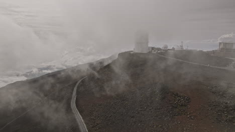 Maui-Hawaii-Aerial-v30-flyover-and-around-Haleakala-Observatory-located-on-mountain-summit,-high-altitude-science-city,-research-facilities-above-the-clouds---Shot-with-Mavic-3-Cine---December-2022
