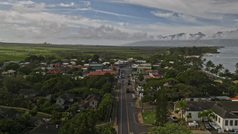 Paia-Maui-Hawaii-Aerial-v5-flyover-town-center-along-Hana-highway-capturing-views-of-scenic-coastal-drive-and-West-Maui-mountains-landscape-on-the-skyline---Shot-with-Mavic-3-Cine---December-2022