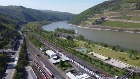 Flying-over-Bingen-am-Rhein-train-station-towards-mouse-tower-and-Burg-Ehrenfels-Castle-in-middle-Rhine-valley