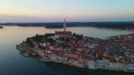 Tilt-up-Aerial-shot-of-panorama-of-sunset-in-the-old-town-of-Rovinj,-Istria,-Croatia