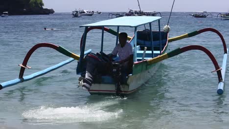 Tour-boats-cruise-in-the-waters-of-Crystal-Bay-beach,-Nusa-Penida-Island,-Bali,-Indonesia