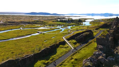 Drone-shot-with-in-the-foreground,-the-lava-rock-to-come-revealed-the-Almannagjá-fault,-Thingvellir-national-park,-Iceland