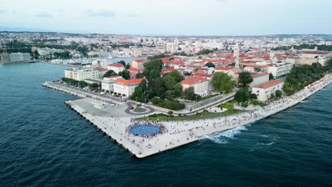Aerial-over-the-Zadar-Sunset-Monument-Sea-Coast,-also-known-as-the-Monument-to-the-Sun,-is-a-captivating-and-innovative-art-installation-located-in-the-beautiful-Croatian-city-of-Zadar