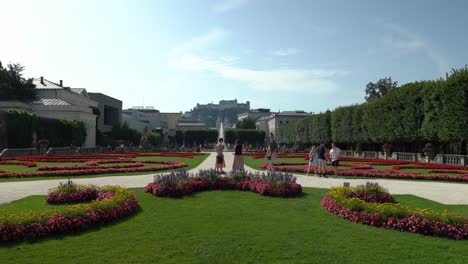 Tourists-Posing-in-Front-of-Mirabell-Palace-Gardens-and-Fortress-Hohensalzburg-in-Background