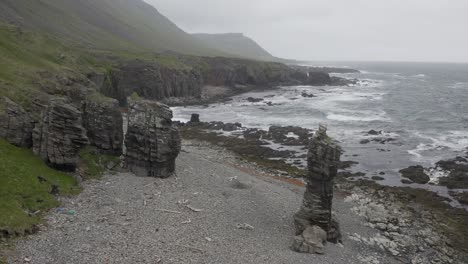 Rocas-En-La-Escarpada-Costa-Islandesa-Con-Olas-Del-Océano-Salpicando