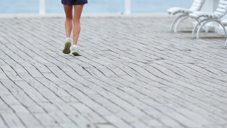 Slow-Motion-Capture-of-Woman-Jogging-on-Brick-Paved-Road,-Lower-Half,-Legs