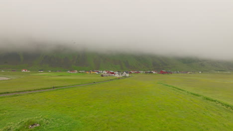 Drone-Fly-with-Oystercatchers-Over-Fog-Enveloped-Mountain-and-Peaceful-Village-in-Lofoten