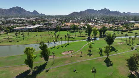 Golf-course-with-palm-trees-and-mountains-in-background