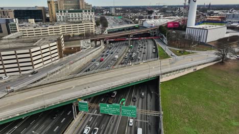 Aerial-birds-eye-shot-showing-driving-cars-on-multi-lane-road-in-Atlanta-City,-USA---Tilt-up