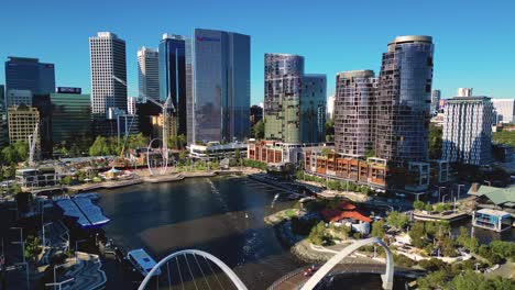 Aerial-drone-forward-moving-shot-over-newly-constructed-Elizabeth-Quay-Bridge-surrounded-by-skyscrapers-in-Perth,-Western-Australia-on-a-sunny-day