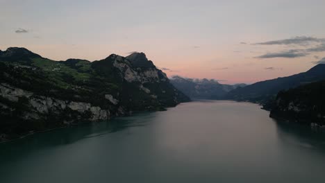 Drone-panning-over-the-lake-with-mountain-and-beautiful-sky-near-Walensee-lake,-Switzerland