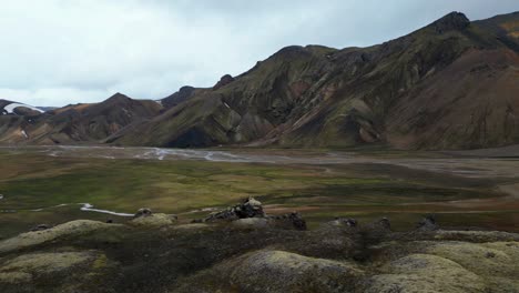 Unglaubliche-Berg--Und-Flussluftaufnahmen-Von-Landmannalaugar-Im-Isländischen-Hochland-Im-Sommer,-Im-Kontrast-Zu-Lavafeldern-Und-Verschiedenen-Grün--Und-Gelbtönen