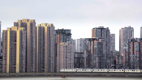 El-Metro-De-Chongqing-Sobre-El-Suelo-Pasa-Frente-A-Edificios-De-Apartamentos-Con-El-Brillo-Del-Atardecer.