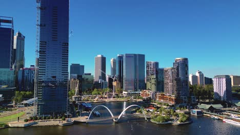 Aerial-drone-shot-flying-high-over-Elizabeth-Quay-Bridge-with-view-of-skyscrapers-in-the-background-in-Perth,-Western-Australia-on-a-sunny-day