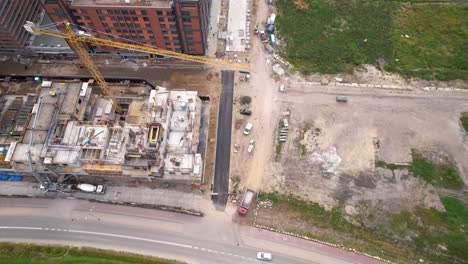Aerial-top-down-shot-of-construction-site-with-crane-and-machinery-for-housing-area