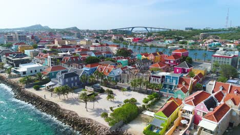 Vibrant-red-yellow-blue-building-facades-of-Punda-Willemstad-Curacao-along-clear-Caribbean-coastal-waters