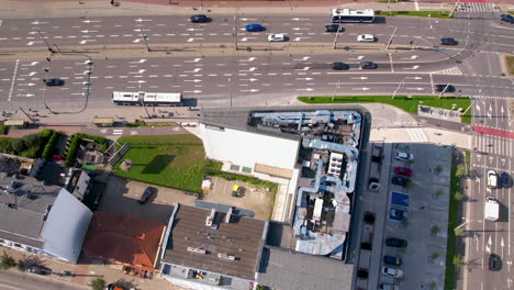 Hohe-Drohnenansicht-Der-Straßenkreuzung-Der-Stadt-Neben-Einem-Flachbau-4k