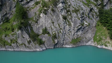 broken-mountain-wall-creating-different-shapes-from-the-damage-it-has-taken-over-time-pieces-of-the-stone-fell-down-uneven-surface-pure-vivid-aqua-water-with-perfect-hue-saturation-amazing-nature