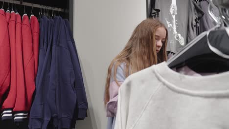 What-should-I-choose-asks-a-young-girl-browsing-through-clothing-store