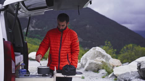 male-trekker-camper-climber-cooking-food-outdoor-in-his-own-camping-car-van-life
