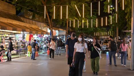 People-walking-and-looking-around-for-something-to-buy-or-eat-at-the-famous-Chatuchak-night-market-in-Bangkok,-Thailand