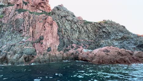 Volcanic-impressive-rock-formations-of-Calanques-de-Piana-in-Corsica-island-as-seen-from-moving-boat-in-summer-season,-France