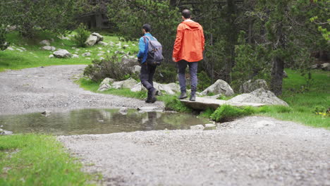 couple-of-trekker-walking-on-mountains-narrowed-path-Aigüestortes-National-Park-located-in-the-Catalan-Pyrenees-Spain