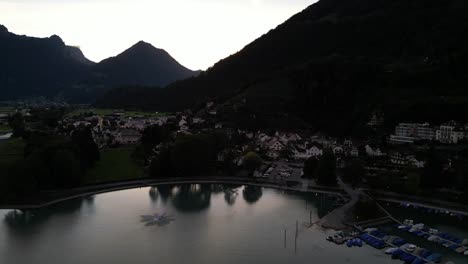 Aerial-drone-view-of-Weesen-town-based-near-shore-of-Walensee-lake,-Switzerland-in-the-early-morning