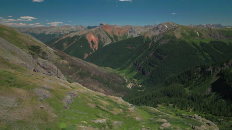 Aerial-drone-cinematic-Ice-Lake-Basin-trail-hike-Silverton-Ouray-Red-Mountain-Pass-Colorado-dreamy-heavenly-Rocky-mountain-scene-lush-green-wildflower-summer-snow-melting-Rocky-peaks-circle-movement